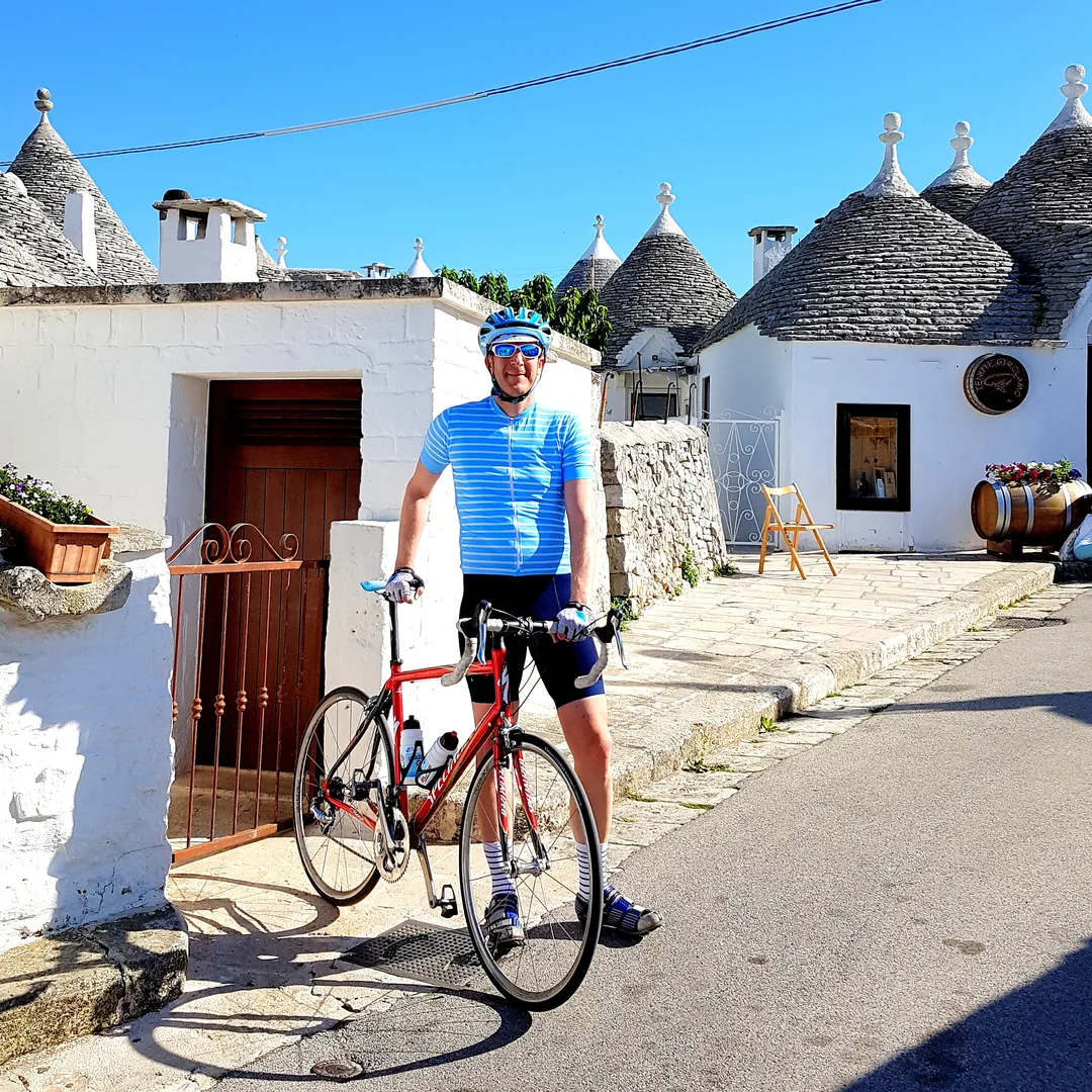 Jens Depenau mit seinem Rennrad zwischen den weißen Trulli von Alberobello